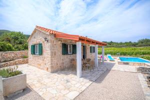 ein kleines Steinhaus mit einem Pool in der Unterkunft Olive Grove house in Račišće