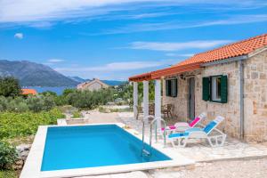 a villa with a swimming pool and a house at Olive Grove house in Račišće