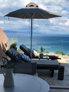 an umbrella sitting on top of a table next to the ocean at Villa Renata Gold in Barbati
