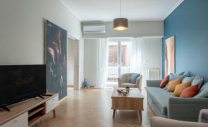 een woonkamer met een blauwe bank en een tv bij DARSISS 2 - Museum Apartment in Athene