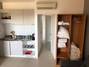 a kitchen with white cabinets and a sink at Porticcio centre plage à pieds, studio-cabine 4 Pers max, promo 7 nuits in Porticcio