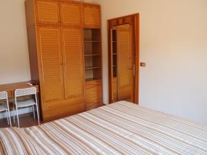 a bedroom with a bed and a wooden closet at B&B Villa Filotea & Apartment in Desenzano del Garda