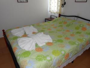 a bed with white towels and flowers on it at Villas Michalis in Chorafakia