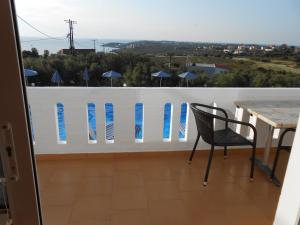 a table and a chair on a balcony with surfboards at Villas Michalis in Chorafakia