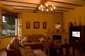 a living room with a couch and a tv at Casa de la Higuera in Priego de Córdoba