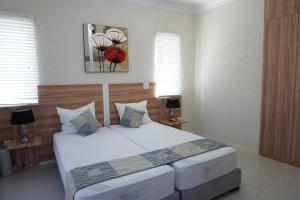 una camera da letto con un grande letto bianco con due cuscini di High-End finished apartment Higher Heights, Barbados a Christ Church