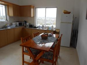 a kitchen with a table with chairs and a refrigerator at Villas Michalis in Chorafakia