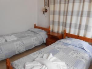 a bedroom with two twin beds and a curtain at Villas Michalis in Chorafakia