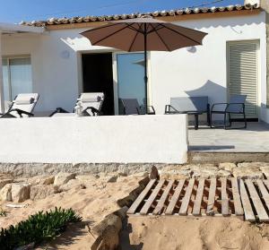 patio con sedie e ombrellone su casa di A(m)mare - casa vacanze a Donnalucata