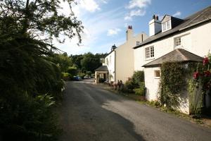 una strada vuota davanti a una casa di The Rock Inn a Bovey Tracey