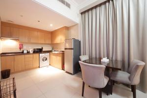 a kitchen with a table with chairs and a refrigerator at SHH - Furnished Studio Apartment, Lincoln Park B, Arjan in Dubai