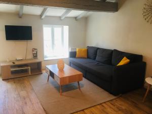 salon z niebieską kanapą i stolikiem kawowym w obiekcie Au pied de la Cité w Carcassonne