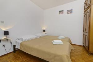 um quarto com uma cama com duas toalhas em Apartments Ive - with sea view em Tisno