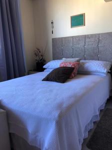 1 cama blanca grande con 2 almohadas en Centro Studio en Uruguaiana