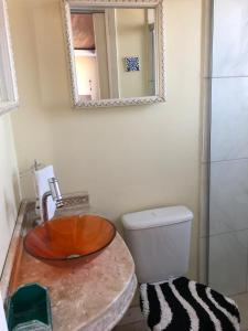 a bathroom with a sink and a toilet and a mirror at Centro Studio in Uruguaiana