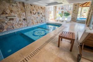 una piscina con un banco de madera frente a ella en Haras del Bosque en Mar de las Pampas