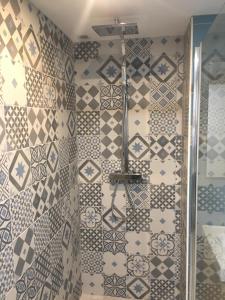 a bathroom with a shower with a tiled wall at T3 Nausicaa Parking gratuit in Boulogne-sur-Mer