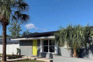 a white house with palm trees in front of it at Near Beaches & IMG Academy, Mins to Downtown in Bradenton