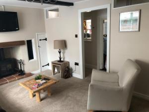 a living room with a chair and a coffee table at A quaint Wymondham cottage in Norwich