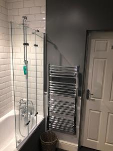 Łazienka z prysznicem i wanną ze szklanymi drzwiami w obiekcie A quaint Wymondham cottage w mieście Norwich