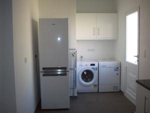 uma cozinha com uma máquina de lavar roupa e uma máquina de lavar roupa em Casa Santos em Prazeres