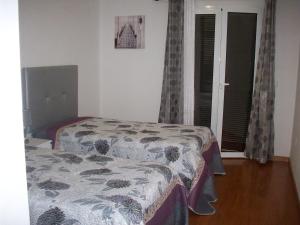 1 dormitorio con 2 camas y ventana en Casa Santos en Prazeres