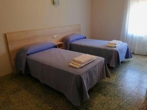 Dos camas en una habitación con toallas. en Apartaments Martí, en La Pobla de Segur
