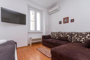 ein Wohnzimmer mit einem Sofa und einem Flachbild-TV in der Unterkunft Apartment Petka in Piran
