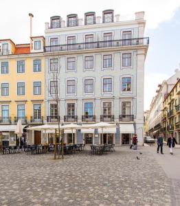 a large building with tables and chairs in front of it at Unique 2 Bdr Apt River View Baixa Alfama C in Lisbon