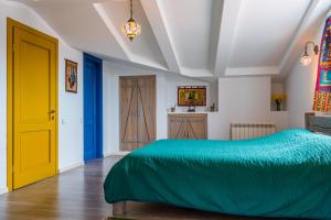 a bedroom with a green bed and a yellow door at Postcard Balconies in Tbilisi City