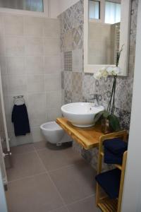 ein Badezimmer mit einem Waschbecken, einem WC und einem Spiegel in der Unterkunft Petite maison in Negrar