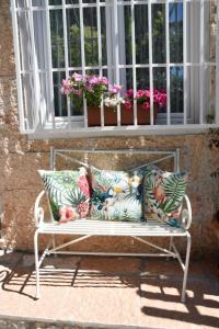 una panchina seduta davanti a una finestra con dei fiori di Petite maison a Negrar
