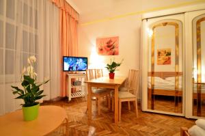 un soggiorno con tavolo e specchio di AJO Apartments - Messe City Flat - Self-Check-in a Vienna