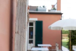 a close up of a building with a column and an umbrella at Relais Villa Isabel in Pietrasanta