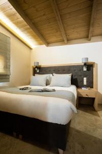 a bedroom with a large bed and a wooden ceiling at Meteora boutique villa E in Kalabaka