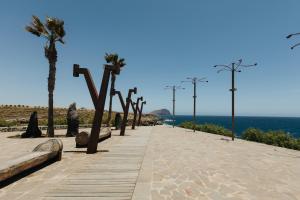 una pasarela con palmeras y el océano en el fondo en El Mirador: sea views from the shore, en Los Abrigos