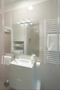 a white bathroom with a sink and a mirror at Victor Residence in Belgrade
