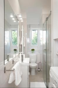 a white bathroom with a toilet and a shower at Victor Residence in Belgrade