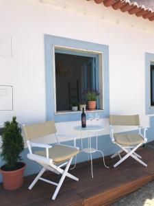 a patio with two chairs and a table and a window at Casa Vila Adentro. Old town traditional house in Aljezur