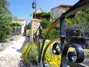 een hek met bloemen voor een huis bij House Dobrila in Igrane +31 foto's