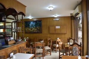 a dining room with tables and chairs and a painting on the wall at Hotel Berlin in Gualeguaychú