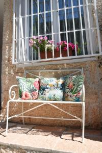 a bench with pillows sitting in front of a window at Petite maison in Negrar