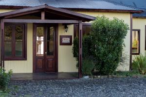 ein Haus mit einer Holztür davor in der Unterkunft Hosteria La Estepa in El Calafate