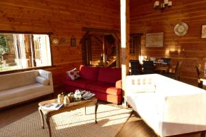 a living room with red and white furniture in a cabin at LA CABAÑA FISHING LODGE in Puerto Ramírez