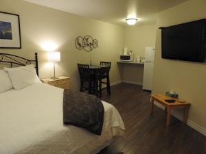 a hotel room with a bed and a table and a television at Jubilee Ocean Front in Topsail