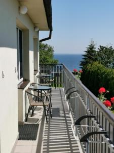un balcón con mesas y sillas y el océano en Pokoje U Wojtka Z Widokiem Na Zatokę, en Swarzewo