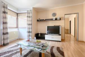 a living room with a tv and a table at H-Apartments in Trier