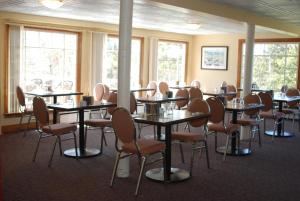 uma sala de conferências com mesas, cadeiras e janelas em Shining Waters Country Inn em Cavendish