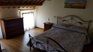a bedroom with a bed and a dresser and a window at Alloggio Ca' dei Frati in Carceri