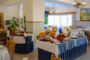 a dining room with blue tables with food on them at Hotel Beira Dão in São Gemil